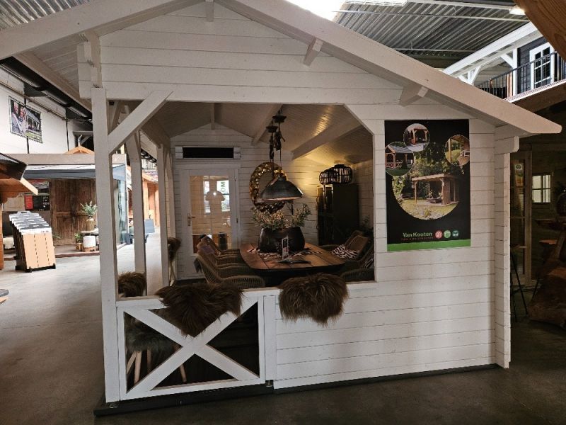 Interflex 6732 Blokhut 667x320 cm 40 mm vuren compleet wit gecoat incl. zwarte dakshingles (tweezijdig), antraciet goot (eenzijdig), composiet funderingsbalken en vlonder in luifel - Showmodel Hoofddorp